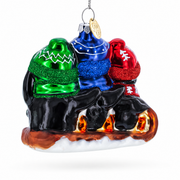 Penguin Trio Sledding Glass Christmas Ornament